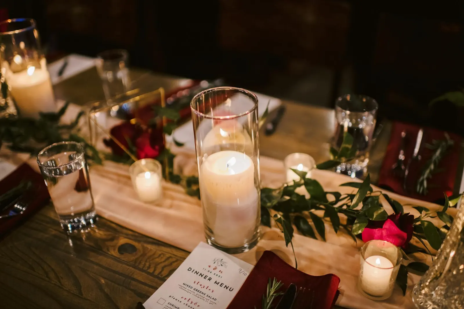 A long candlelit dinner table set for a private event