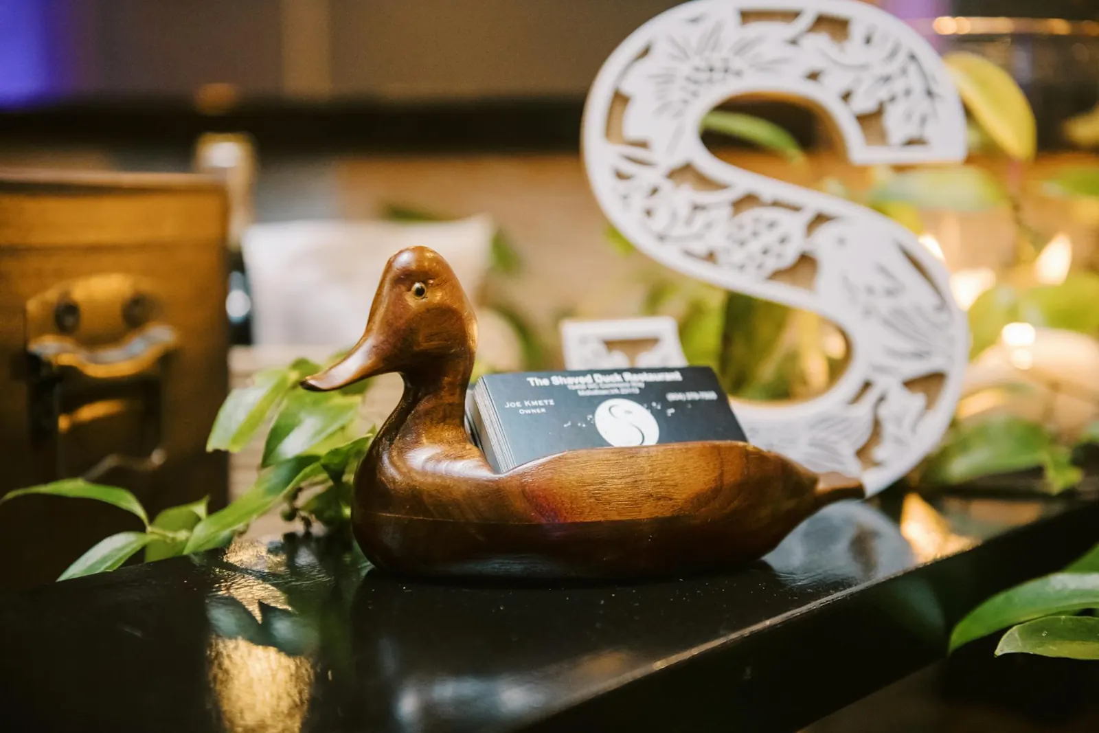 A carved wooden duck, a nod to the family collection behind the name