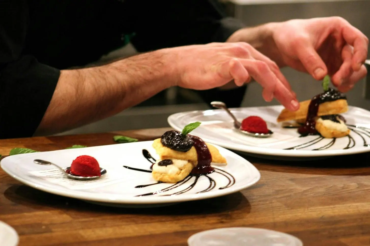 A chef plating a dessert course for the chef's table