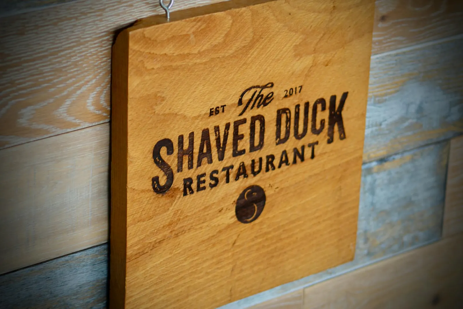 The Shaved Duck wood sign inside the restaurant